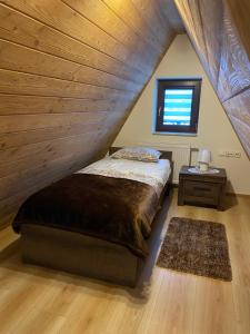 ein Schlafzimmer mit einem Bett und einer Holzdecke in der Unterkunft Apartamenty Natalii in Nowy Targ