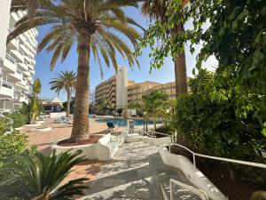 un resort con palme e piscina di Sunsets Sur Ponderosa a Playa Fañabe