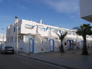 a white building with blue doors on a street at Precioso apartamento en Cabo de Gata in El Cabo de Gata