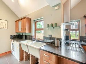 a large kitchen with a sink and a dishwasher at Firs Retreat in Balderton