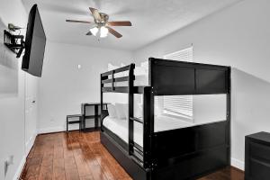 1 dormitorio con litera negra y ventilador de techo en *Heart of Houston* Pet friendly/14ppl/4br/2.5b, en Houston