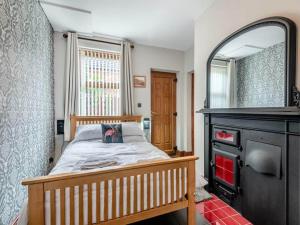 a bedroom with a bed with a mirror and a fireplace at Firs Retreat in Balderton