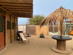 une terrasse avec une table et une balançoire dans l'établissement Pepon Surf Camp, à Máncora