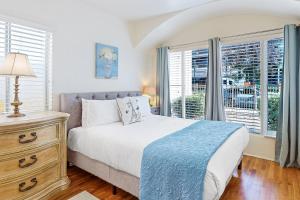 a bedroom with a bed and a dresser and windows at Little Italy Charmer in San Diego
