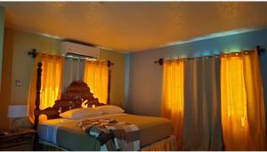 1 dormitorio con 1 cama con cortinas amarillas en Hill view Vacational Rental, en Runaway Bay