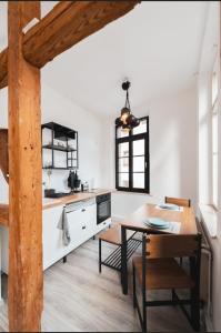 a kitchen with white walls and a wooden table at Castle View Appartment in Nuremberg