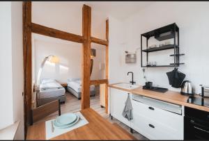 een kleine keuken met een wastafel en een slaapkamer bij Castle View Appartment in Neurenberg