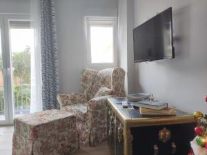 a living room with a chair and a tv at Annie's Home in Heraklion