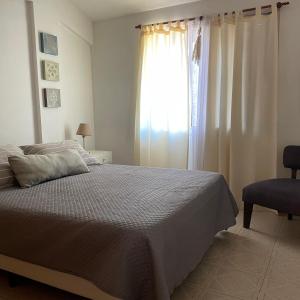 1 dormitorio con cama y ventana grande en Dpto para 2 personas con cochera, EXCELENTE UBICACIÓN! en Villa Carlos Paz