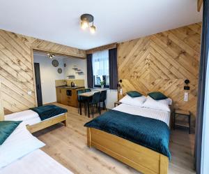 Habitación de hotel con 2 camas y mesa en Willa Janowa, en Bukowina Tatrzańska