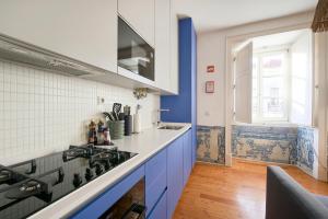 eine Küche mit blauen und weißen Wänden und einem Herd in der Unterkunft Inglesinhos Convento 1 - Charming Apartment in Lissabon