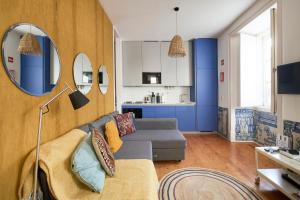 ein Wohnzimmer mit einem Sofa und einer Küche in der Unterkunft Inglesinhos Convento 1 - Charming Apartment in Lissabon