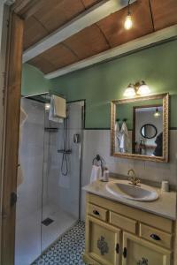 a bathroom with a sink and a shower with a mirror at Casa de Vivar a 5 minutos de Puy du Fou in Cobisa