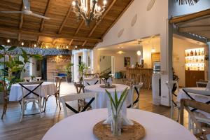 un restaurante con mesas y sillas blancas y una cocina en TAKUMA BOUTIK HOTEL, en Las Terrenas
