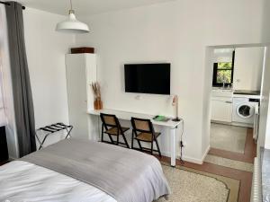 1 dormitorio con 1 cama y escritorio con 2 sillas en LA PARCELLE en Lezennes