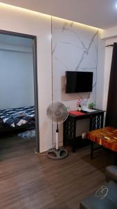 Zimmer mit einem Ventilator, einem Schreibtisch und einem TV. in der Unterkunft C.J Apartments in Olongapo