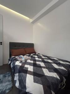 ein Schlafzimmer mit einem Bett mit einer schwarzen und weißen Decke in der Unterkunft C.J Apartments in Olongapo