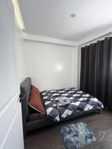 a small bedroom with a bed with a checkered blanket at C.J Apartments in Olongapo