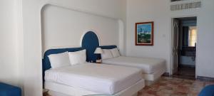 a hotel room with two beds and a window at Hotel & Museo Casa Turquesa in Cancún +41 photos