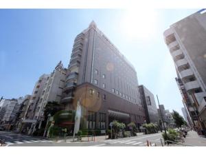 een groot gebouw in een stadsstraat met hoge gebouwen bij Hotel Nagoya Garden Palace - Vacation STAY 25765v in Nagoya