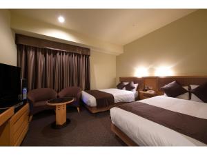 a hotel room with two beds and a flat screen tv at Hotel Nagoya Garden Palace - Vacation STAY 25771v in Nagoya