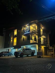 ein Auto, das nachts vor einem Gebäude parkt in der Unterkunft C.J Apartments in Olongapo