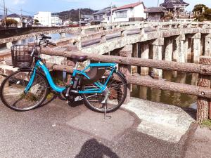 Una bicicleta azul estacionada junto a un puente en Eimiya Ryokan - Vacation STAY 36336v en Amakusamachi