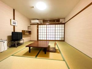 ein Zimmer mit einem Tisch in der Mitte eines Zimmers in der Unterkunft Eimiya Ryokan - Vacation STAY 36263v in Amakusa