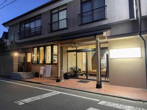 um edifício numa rua da cidade com uma placa em frente em Eimiya Ryokan - Vacation STAY 36348v em Amakusa