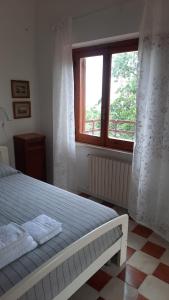 een slaapkamer met een bed en een raam bij Il Porticato - Affittacamere in Paola
