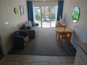 - un salon avec un canapé et une table dans l'établissement Beaches Motel, à Waihi Beach