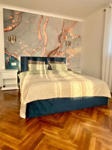a bedroom with a bed with a painting on the wall at Cloos - Elegant Residence with Panoramic View in Braşov