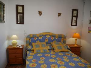 a bedroom with a bed with a blue comforter and two lamps at Precioso apartamento en Cabo de Gata in El Cabo de Gata