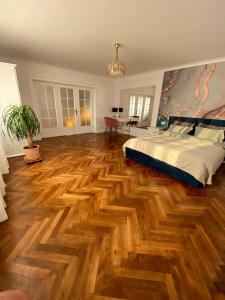 a bedroom with a bed and a wooden floor at Cloos - Elegant Residence with Panoramic View in Braşov