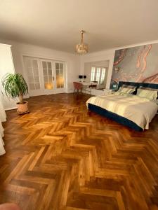 ein Schlafzimmer mit einem Bett und einem Holzboden in der Unterkunft Cloos - Elegant Residence with Panoramic View in Braşov