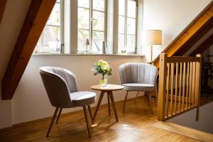 una habitación con 2 sillas y una mesa con flores. en Weingut Haus Steinbach, en Radebeul