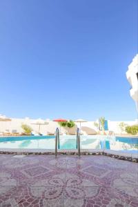 una piscina con sombrillas y el océano en La bonita compound, en Hurghada