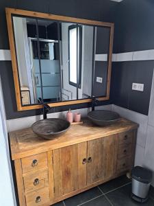 La salle de bains est pourvue de 2 lavabos et d'un grand miroir. dans l'établissement Chambre dans chalet avec piscine, à Saint-Jean-en-Royans