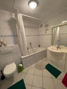 ein Badezimmer mit einem WC, einer Badewanne und einem Waschbecken in der Unterkunft MonteurHaus Am Airport in Bremen