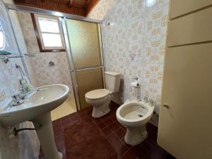 a bathroom with a toilet and a sink at Recanto Habacuque in Campos do Jordão