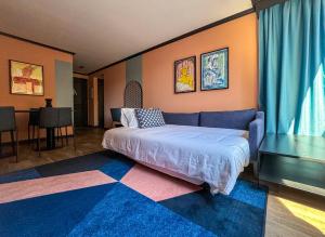 a bedroom with a bed and a blue couch at APT Serviced Apartments Santiago in Santiago