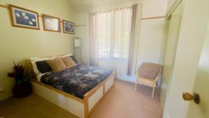 una camera da letto con un letto, una finestra e una sedia di The Garden Cottage a Tawonga Altre 16 foto