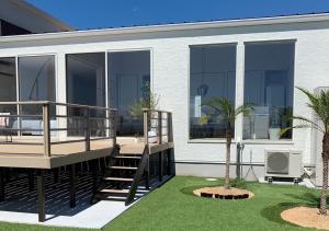 une maison avec des fenêtres en verre et une terrasse avec un palmier dans l'établissement Seagull east coast Awaji - Vacation STAY 21943v, à Awaji