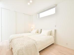 2 camas en un dormitorio blanco con ventana en Seagull east coast Awaji - Vacation STAY 21943v, en Awaji