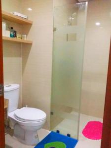ein Badezimmer mit Toilette und Glasdusche in der Unterkunft Studio-Type Condo at Eastwood Legrand 3 in Manila