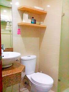 ein Badezimmer mit einer weißen Toilette und einem Waschbecken in der Unterkunft Studio-Type Condo at Eastwood Legrand 3 in Manila