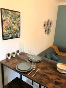 uma mesa de madeira com pratos e copos de vinho em Le Donatien-Cosy appart proche centre et Erdre em Nantes