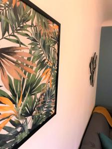 um quadro numa parede com uma pintura de uma planta em Le Donatien-Cosy appart proche centre et Erdre em Nantes