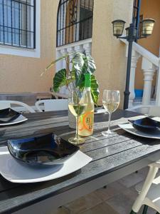 a table with two glasses and a bottle of wine at Bungalow Gran Alacant in Gran Alacant +28 photos