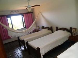 1 dormitorio con 2 camas y ventana en Mansao Santa Rita, en Cumbuco